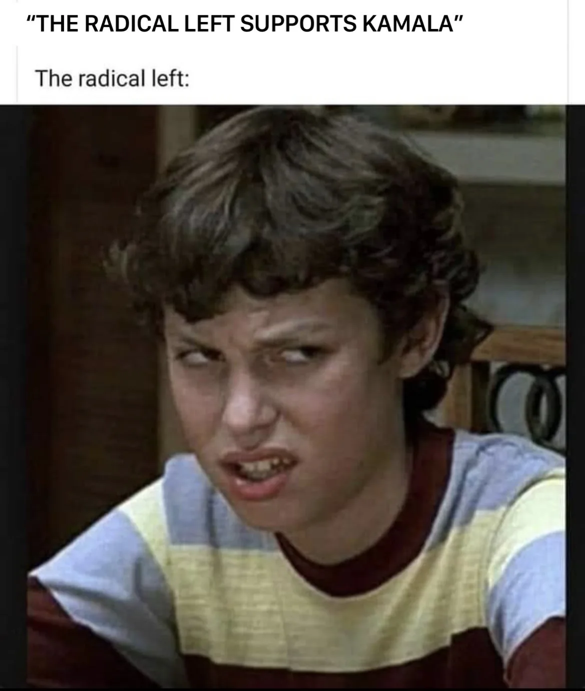 A close-up image of a young boy with curly brown hair wearing a striped shirt, making a disgusted, skeptical, and…