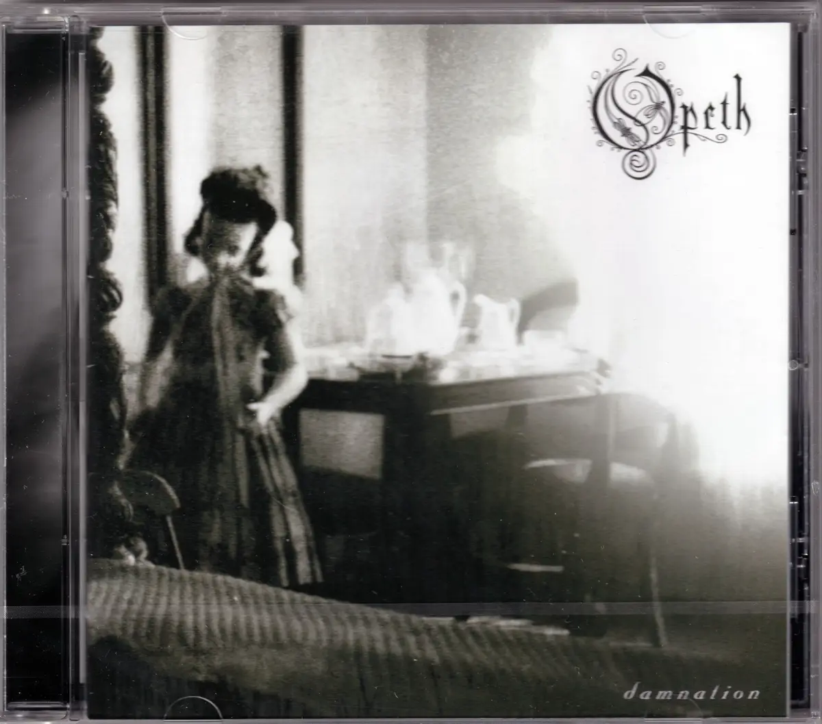 The image shows the cover art for the album 'Damnation' by the band Opeth, featuring a blurry black-and-white photograph of…