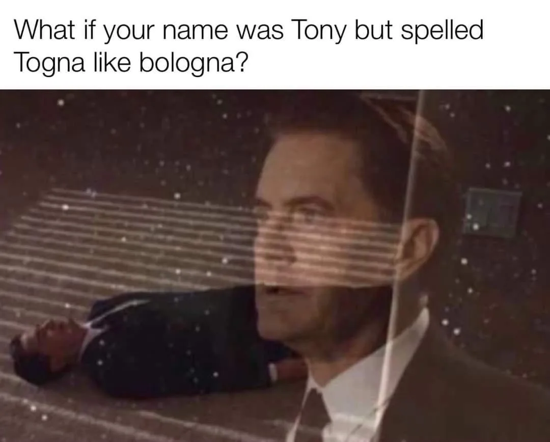 A man in a suit lies on his back on a floor with a starry background, while a translucent overlay of his face looks upward…