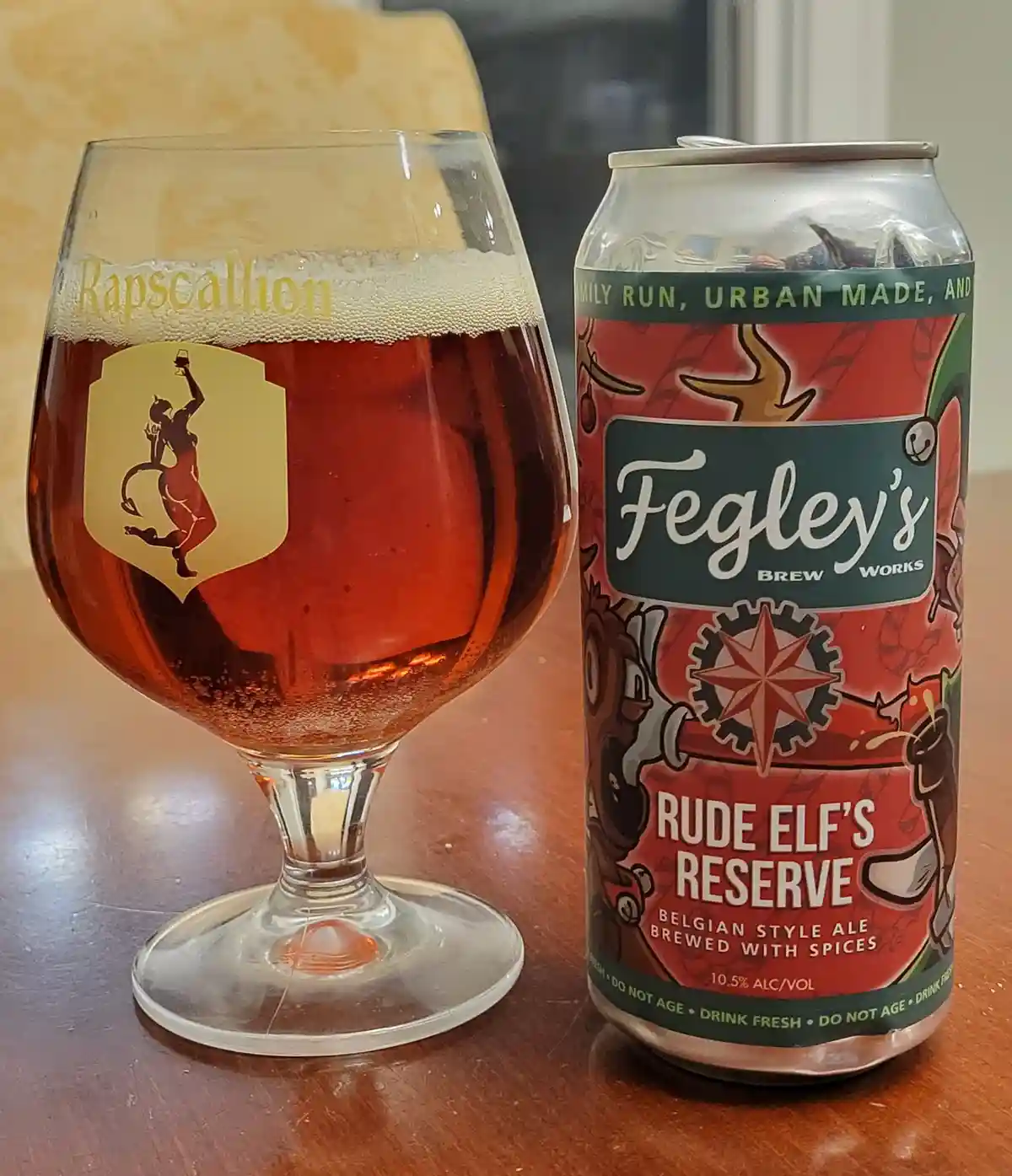 A beer can labeled 'Fegley's Brew Works Rude Elf's Reserve' sits next to a stemmed glass filled with amber beer and topped…