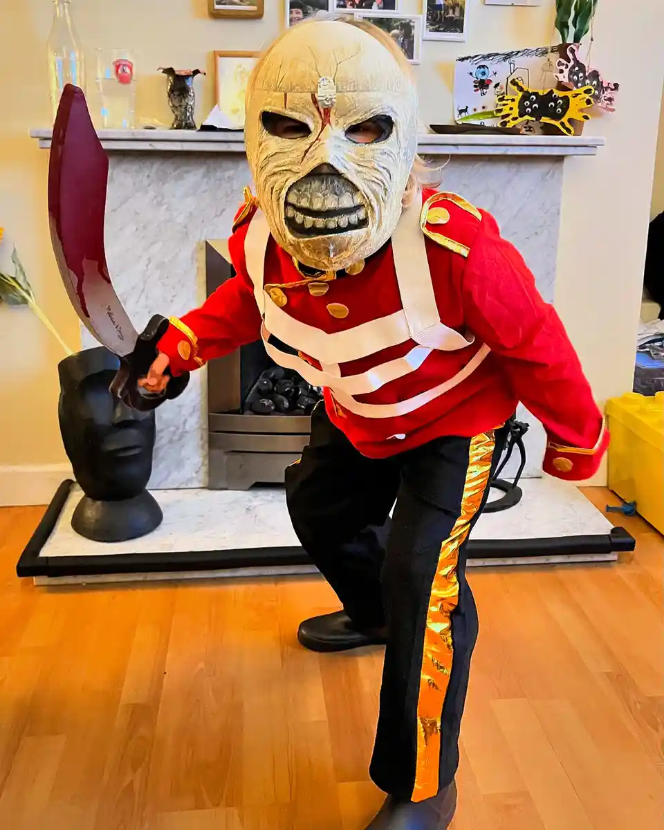 A child dressed in a full Iron Maiden 'The Number of the Beast' Eddie costume, complete with a skull mask, red…
