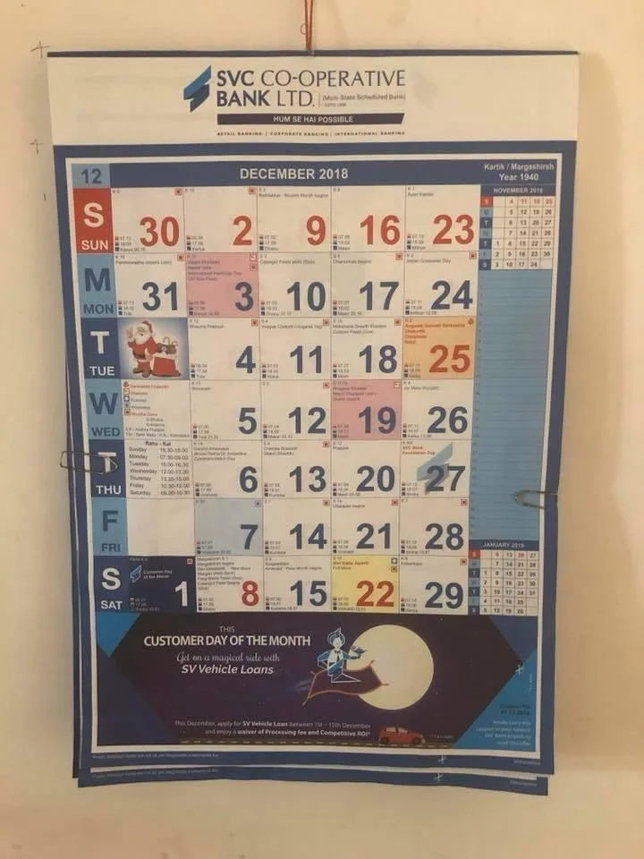 a wall-mounted December 2018 calendar from SVC Co-operative Bank Ltd. features a promotional banner at the bottom…
