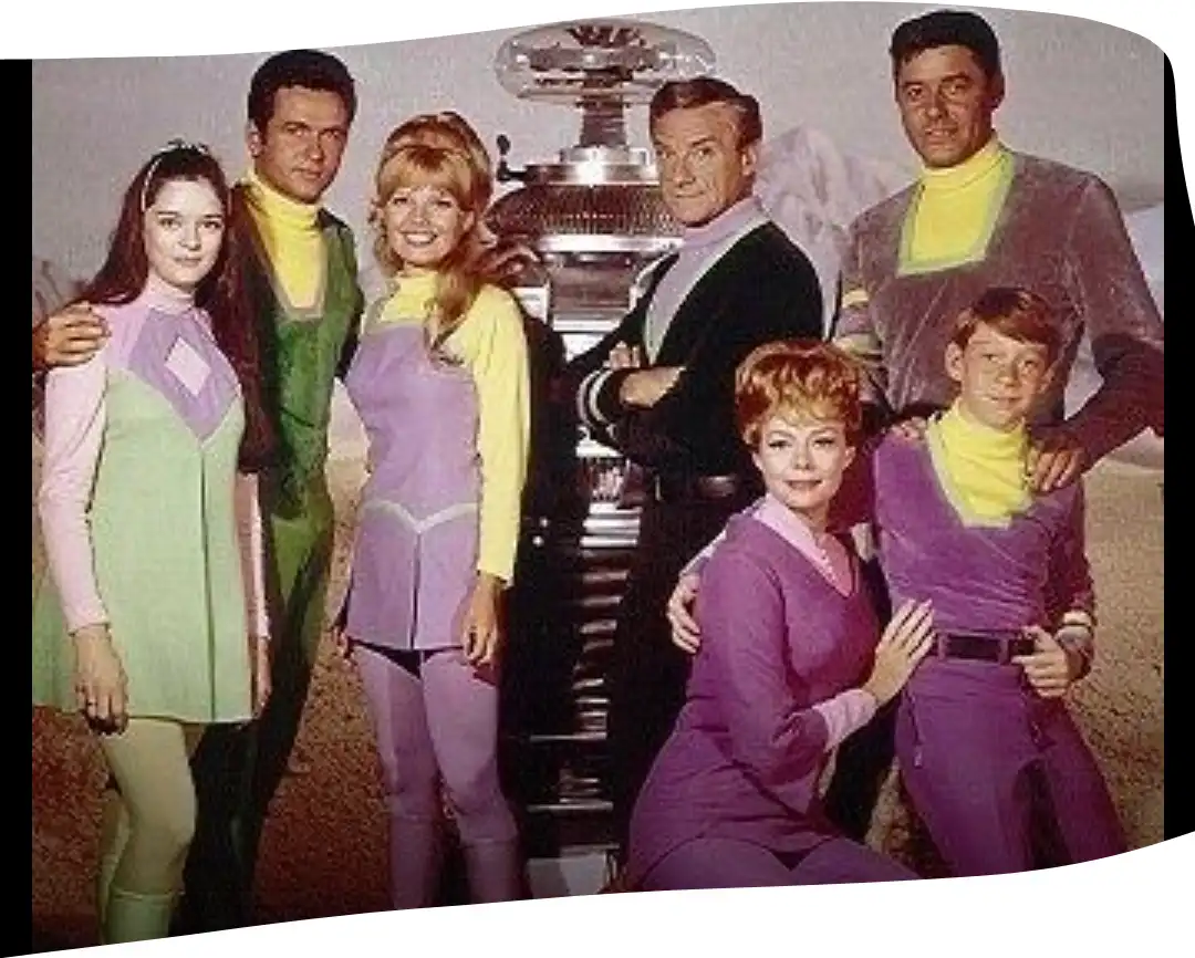 A vintage promotional photo of the cast of 'The Bionic Woman' standing together in their signature colorful, futuristic…