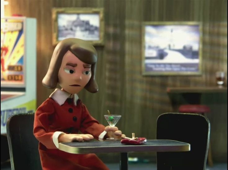 An animated woman with brown bobbed hair, wearing a red coat with white collar and cuffs, sits at a diner table looking…