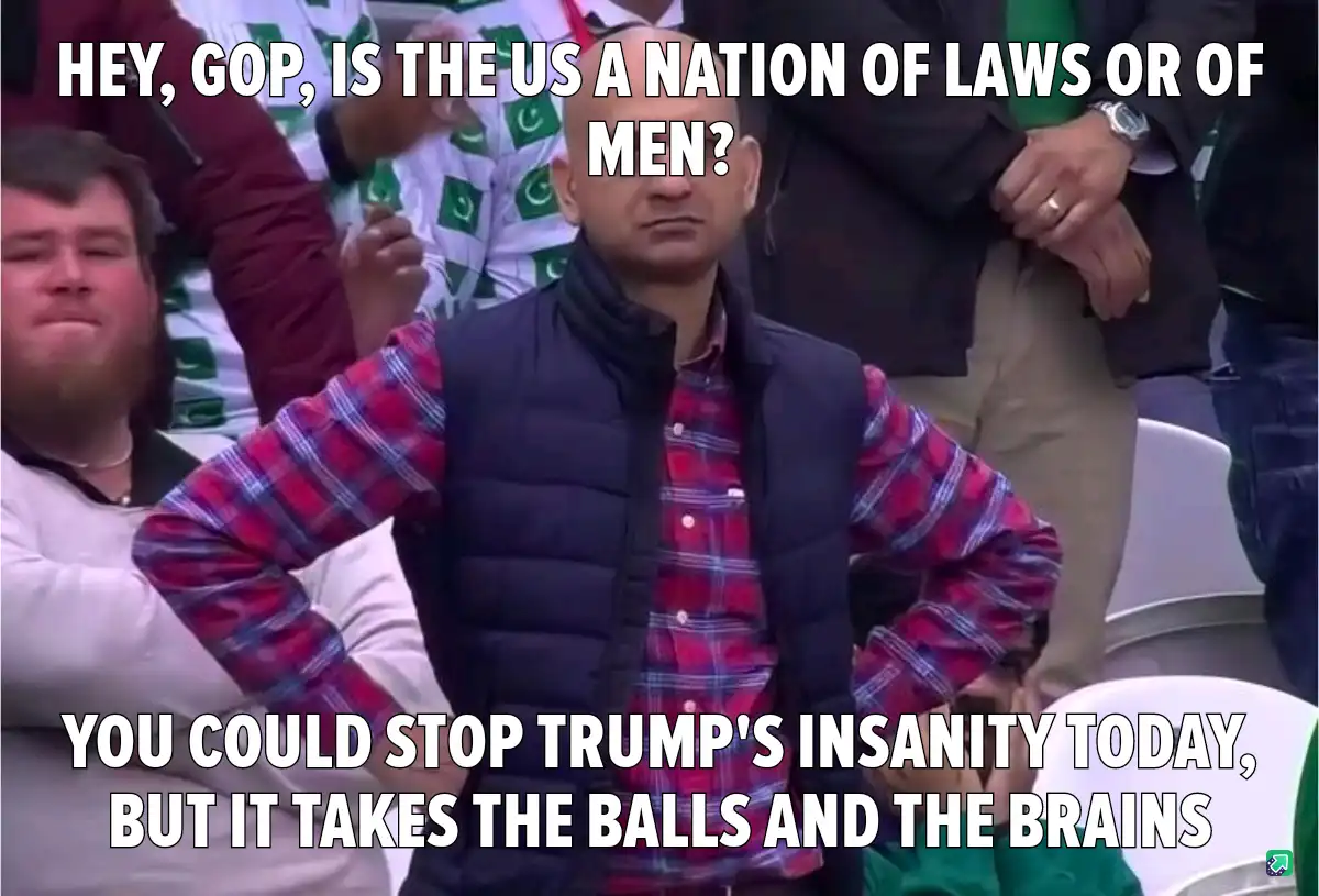 A man in a red plaid shirt and black vest stands with hands on hips, looking sternly at the camera. Overlaid text asks the…