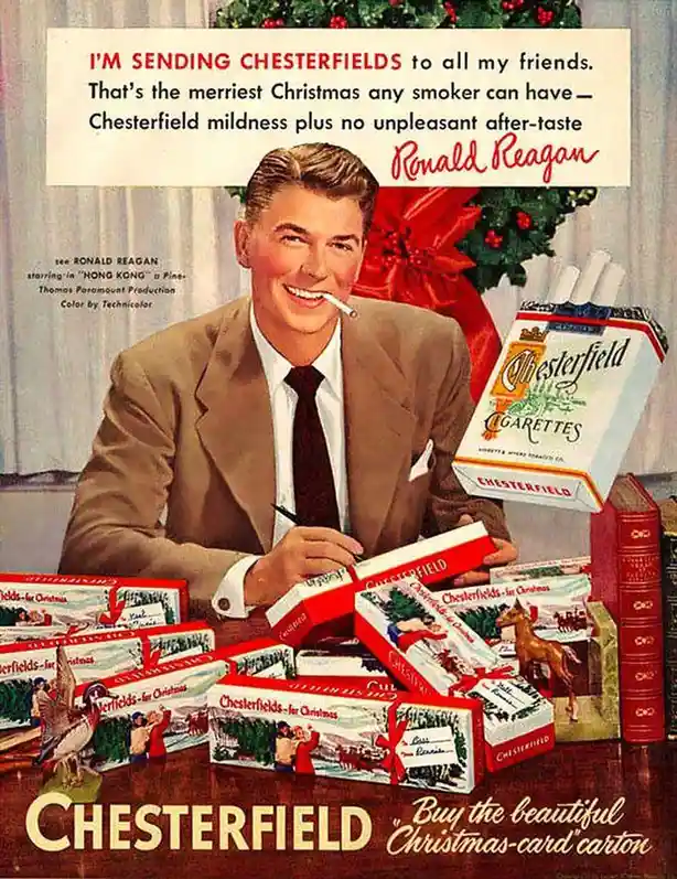 A vintage 1940s Chesterfield cigarette advertisement featuring actor Ronald Reagan smiling while writing a letter surrounded…