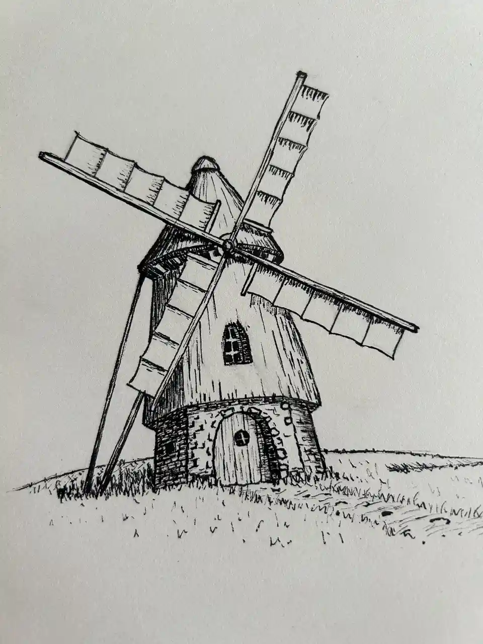 A black-and-white ink drawing depicts a traditional windmill with a stone base, wooden upper structure, arched door, small…