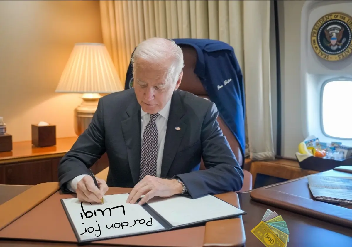 A man in a suit sits at a desk in an airplane office, signing a document with the text 'Pardon for Luigi' written on it. A…