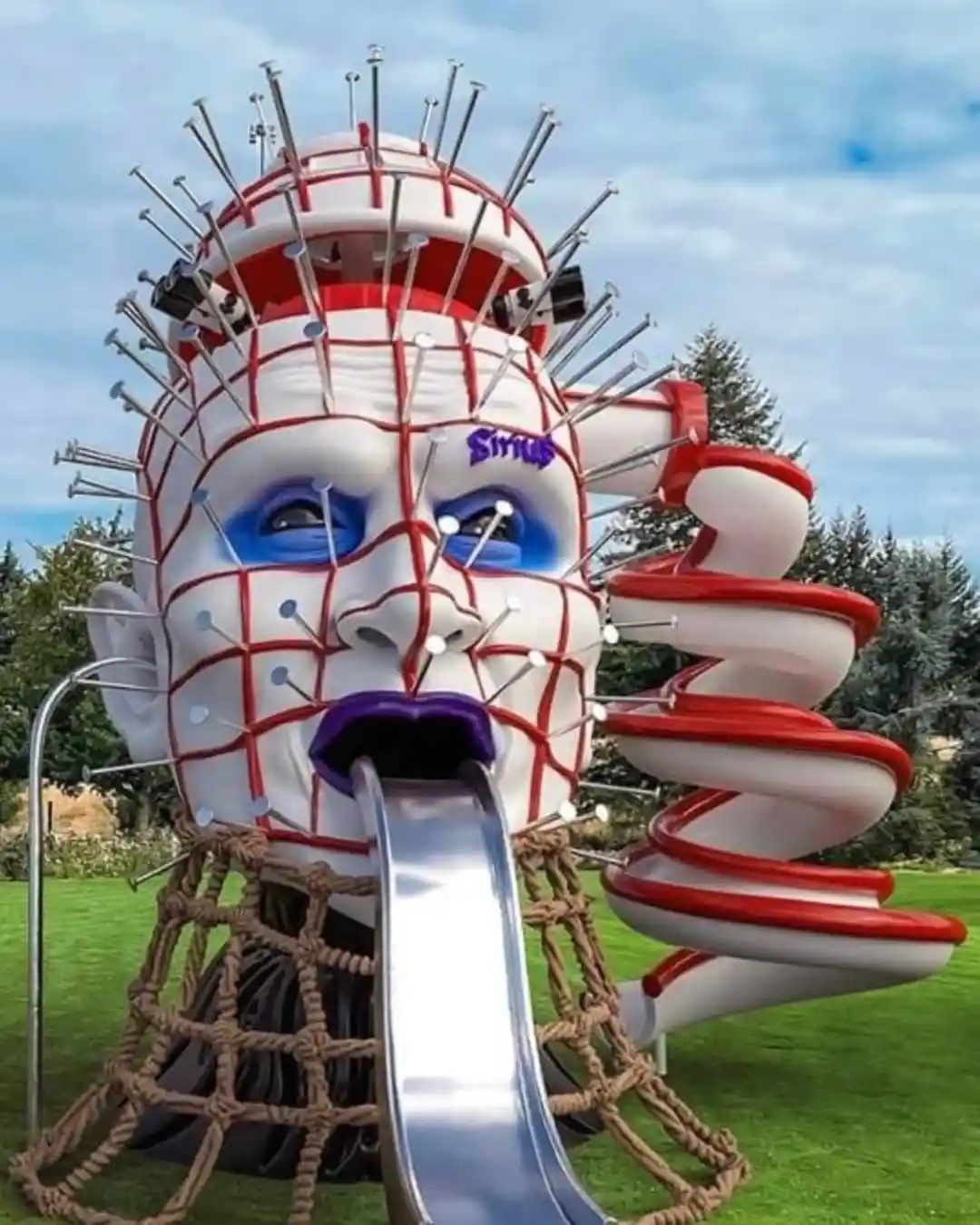 A large, white, grid-patterned playground structure shaped like a human face with blue eyes and purple lips, covered in…