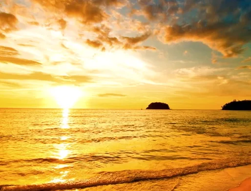 A serene sunset over a calm ocean with golden light reflecting on the water, distant islands silhouetted against the sky…