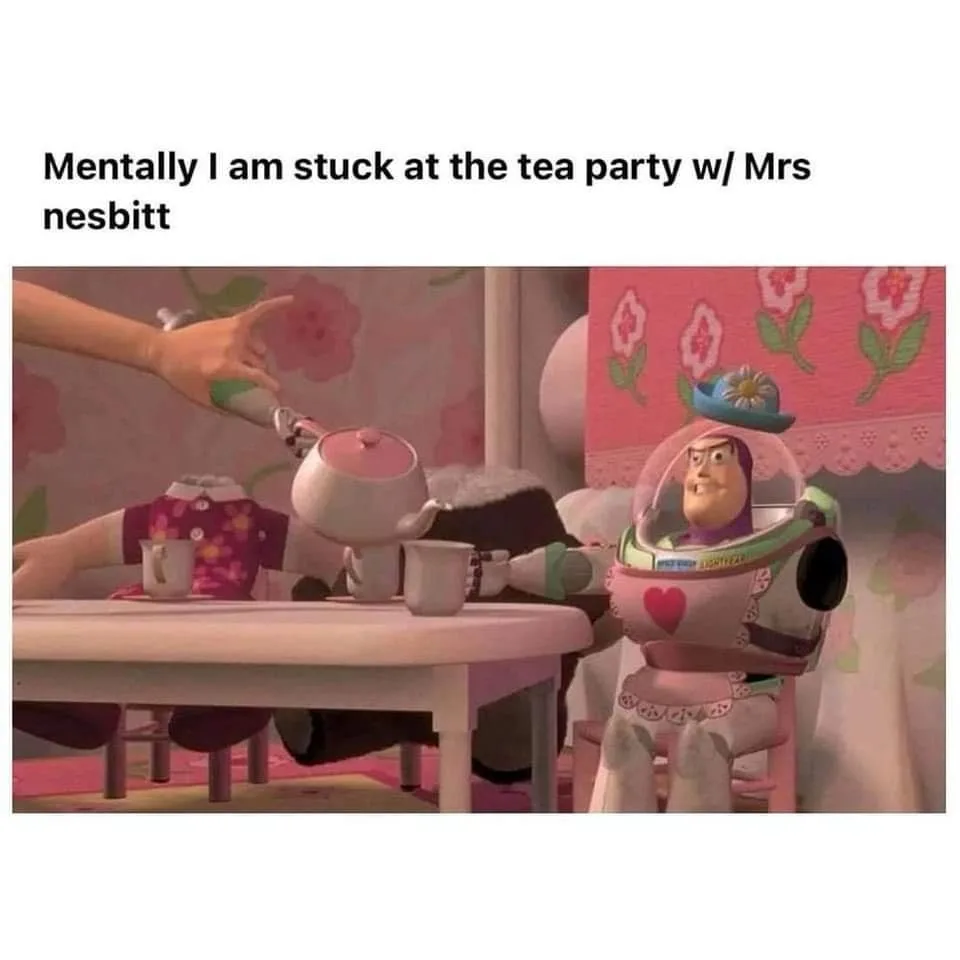 A still from Toy Story shows Buzz Lightyear dressed in a pink tea party outfit with a flower hat, sitting at a small table…