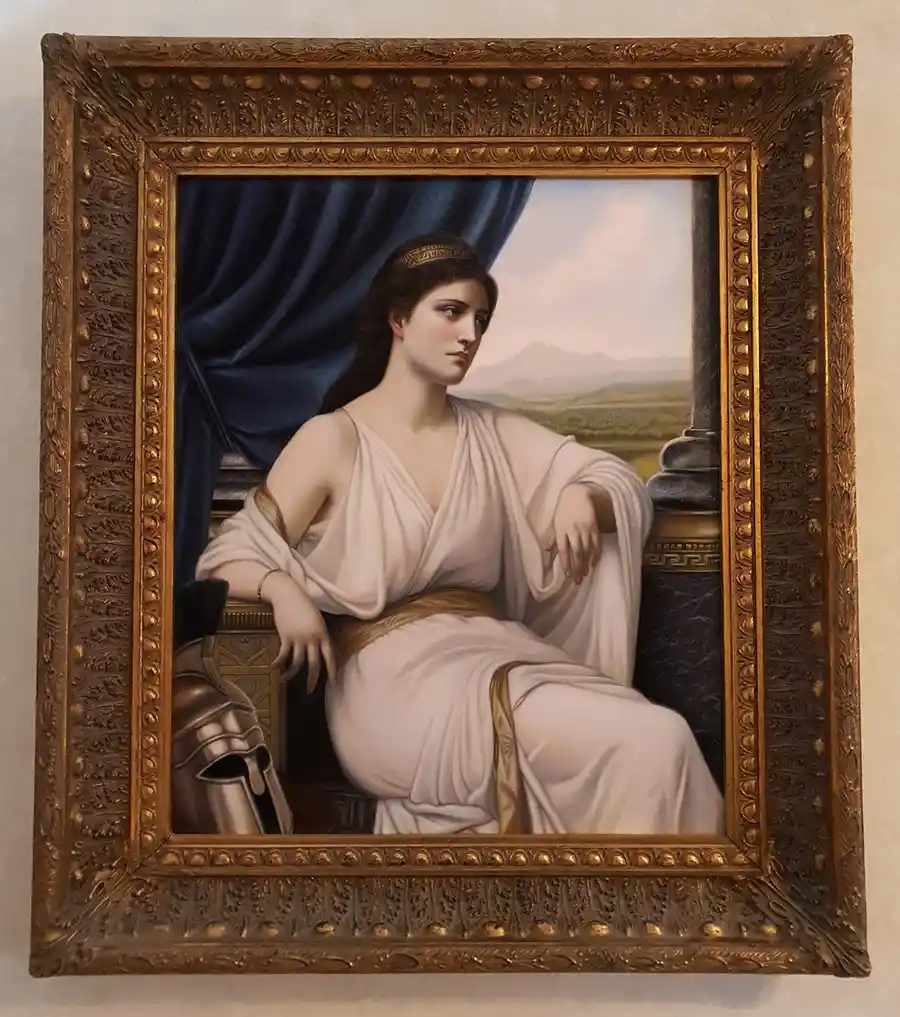 A classical painting of a woman in a white Greek-style robe with gold trim, seated beside a helmet and column, framed in…