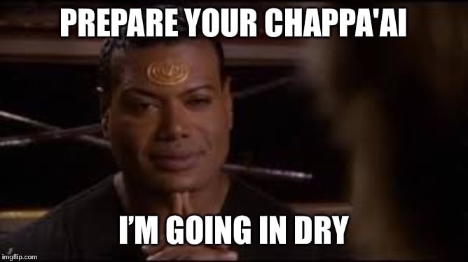 A man with a gold spiral tattoo on his forehead, wearing a dark shirt, looks intensely forward with his hands clasped. The…