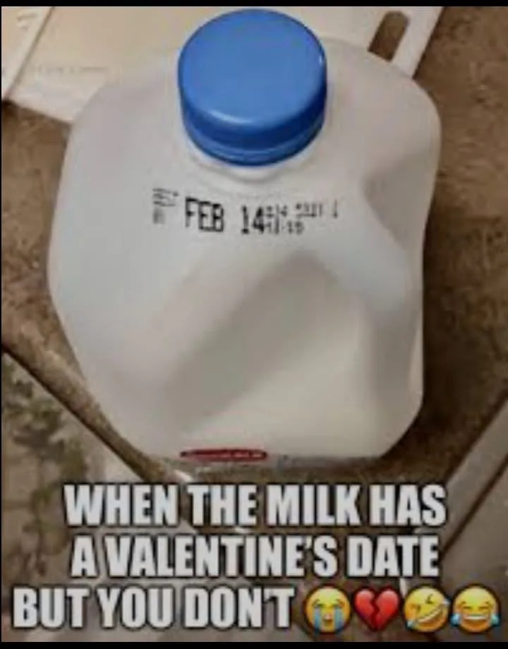 A close-up photo of a white plastic milk jug with a blue cap, sitting on a countertop. The jug has a printed expiration date…