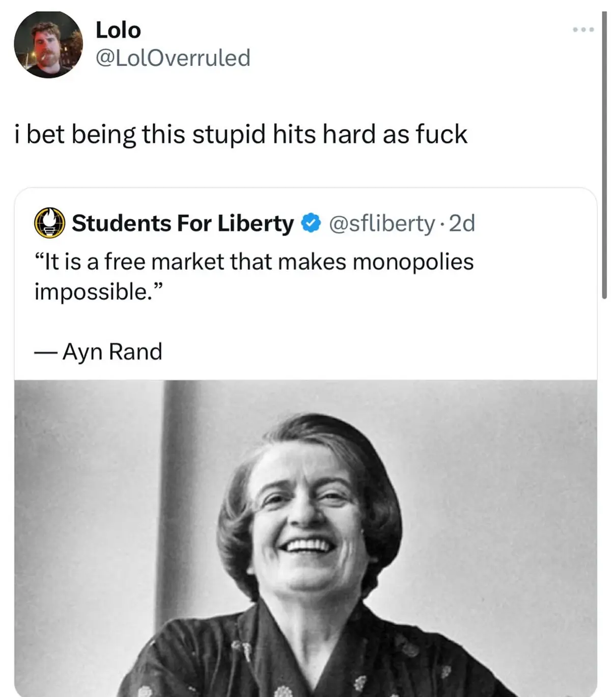 A black-and-white photo of Ayn Rand smiling broadly is overlaid with text showing a tweet from 'Students For Liberty' that…