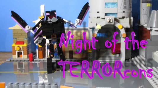 A Lego diorama shows a large black robot with purple accents standing menacingly in front of a Lego building labeled '3'…