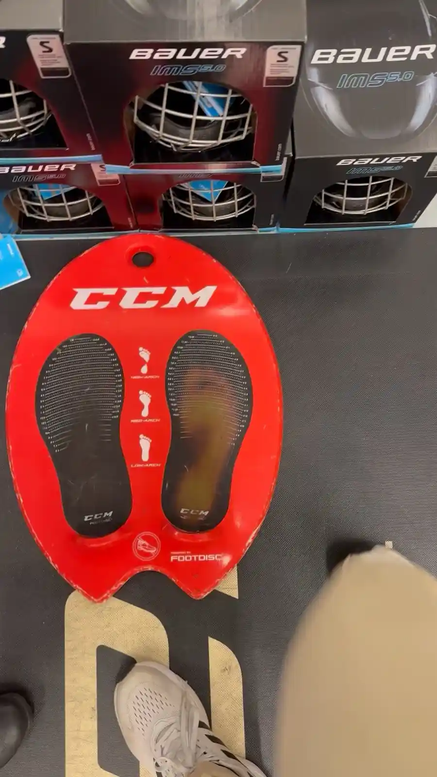 A red CCM FootDisc with two black foot-shaped imprint areas, one showing a clear footprint and the other blank, sits on a…