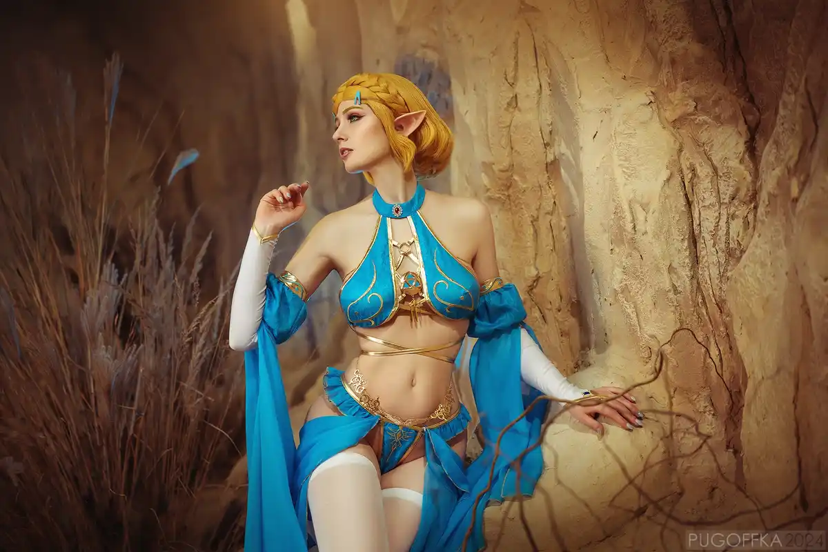 A person in a detailed cosplay of Zelda from The Legend of Zelda: Tears of the Kingdom, wearing a blue and gold outfit with…