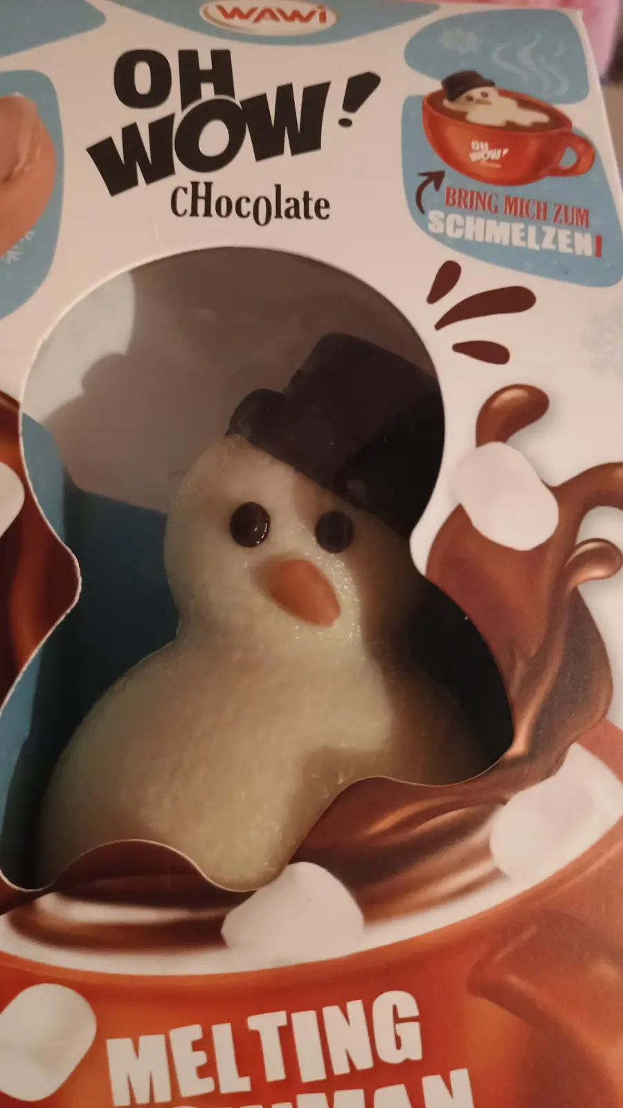 A close-up of a chocolate snowman candy in its packaging, which features the brand name 'WAWI' and the text 'OH WOW!…
