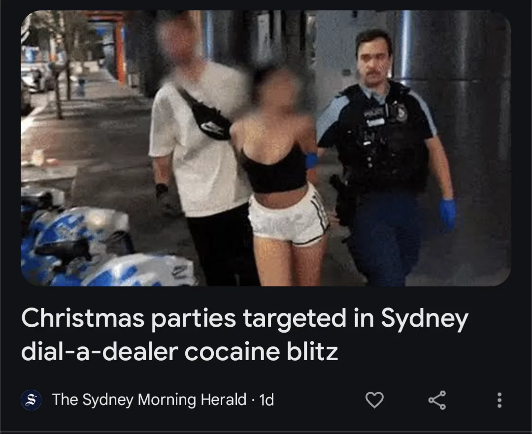 A police officer in uniform walks beside two blurred individuals, one in a white t-shirt and the other in a black top and…
