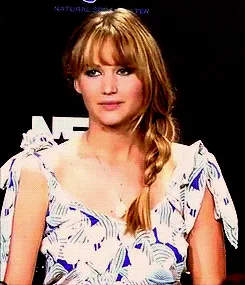 A six-panel image sequence shows actress Jennifer Lawrence at an event, wearing a white and blue patterned dress with a side…