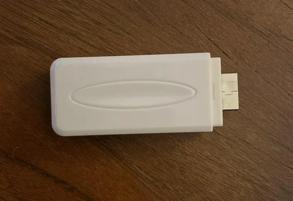 A white USB adapter with a micro-USB connector lies on a wooden surface. The image has overlaid text that reads 'i'm not a…