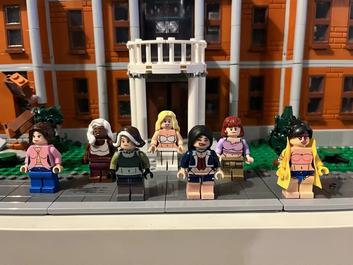 Seven LEGO minifigures, representing female X-Men characters, stand in front of a LEGO building labeled 'MUTANTS MUTANDO'…