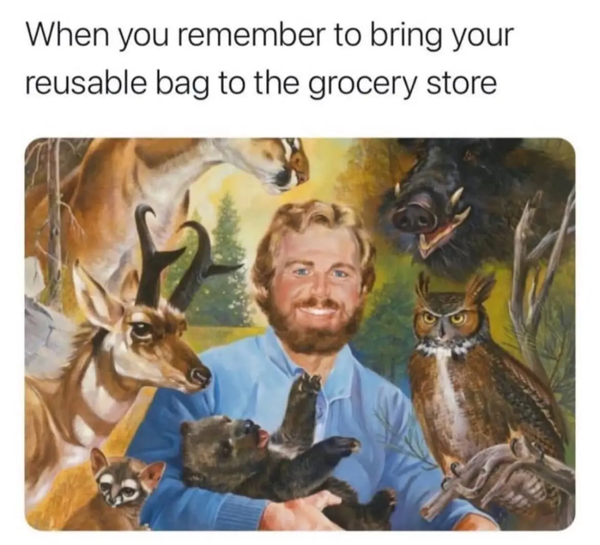 A painting depicts a smiling man in a blue shirt holding a small bear cub, surrounded by various animals including a deer…