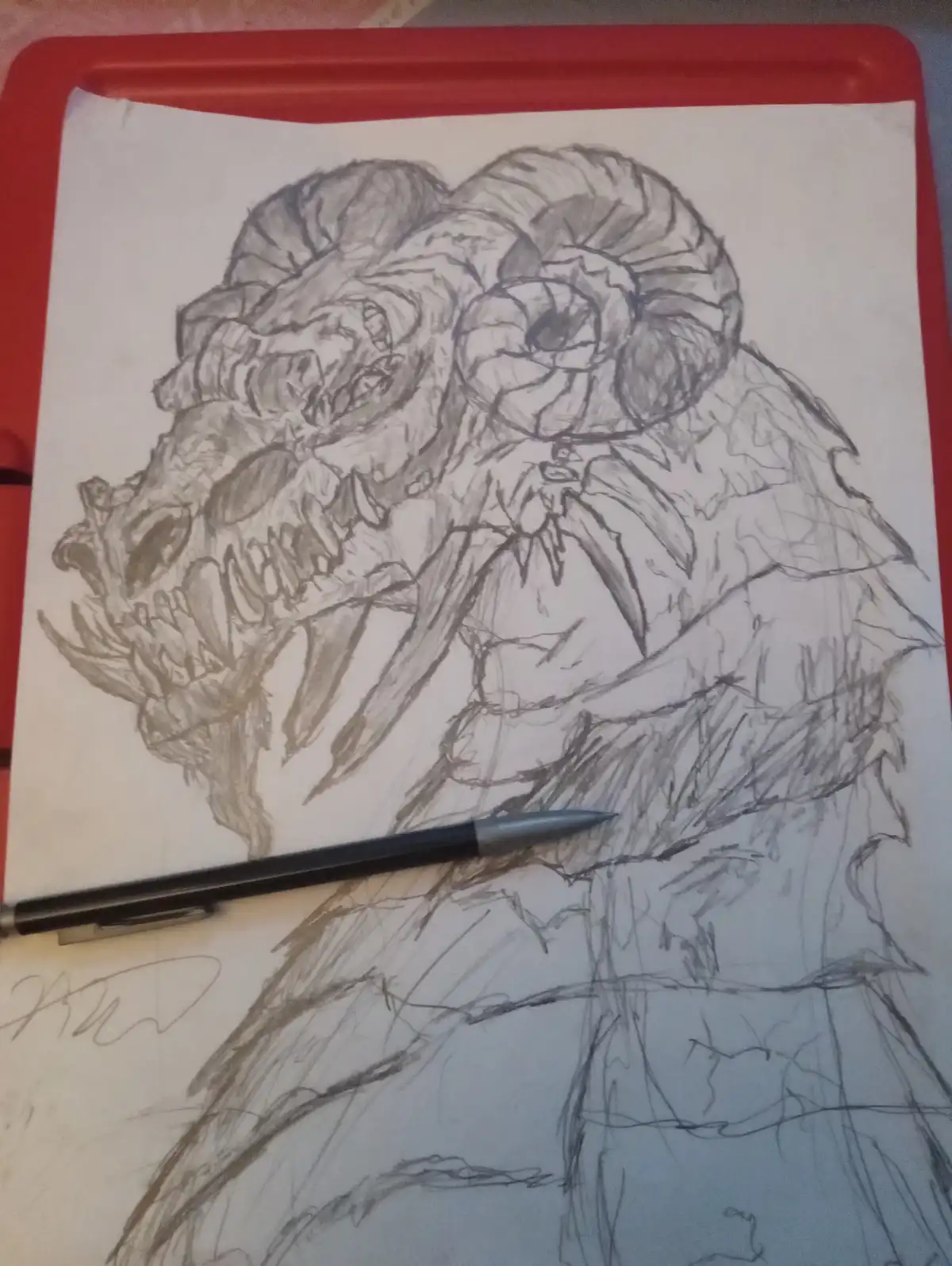 A pencil sketch on paper shows a monstrous creature with large, spiraled horns, a snarling face with sharp teeth, and a…