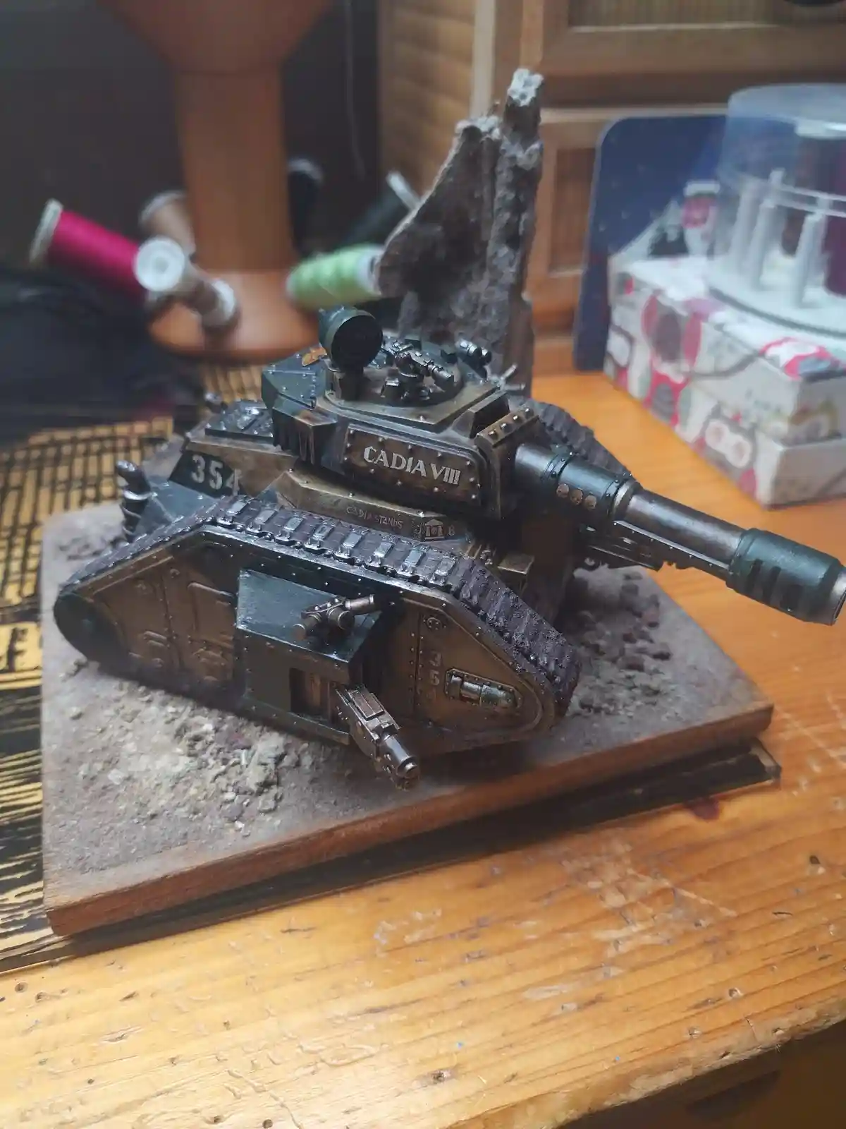 A highly detailed, weathered miniature tank model from the Warhammer 40,000 universe, marked with 'CADIA VIII' and 'CADIA…