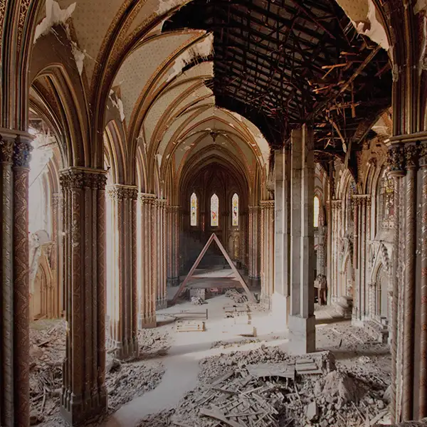 the image shows the interior of a ruined gothic church with collapsed ceilings, broken arches, and rubble on the floor. A…
