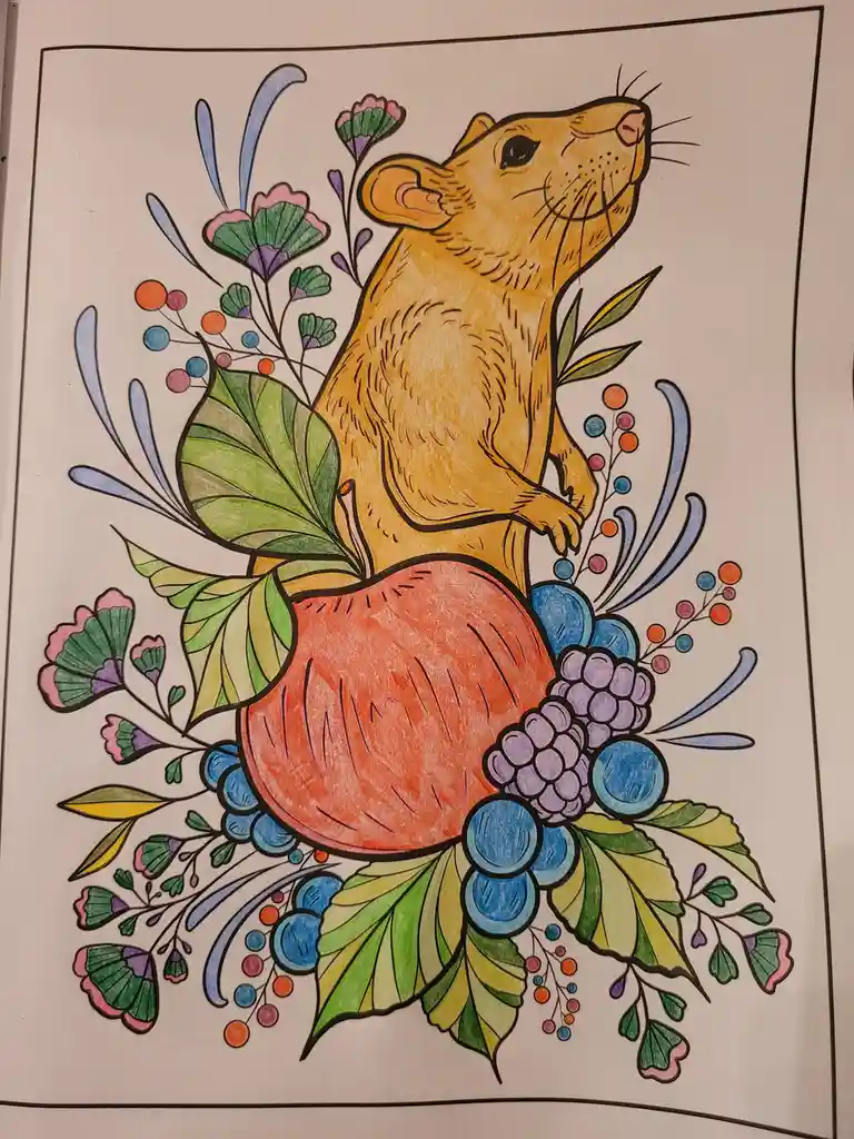 A hand-colored coloring book page shows a yellow rat standing upright on a large red apple, surrounded by colorful foliage…