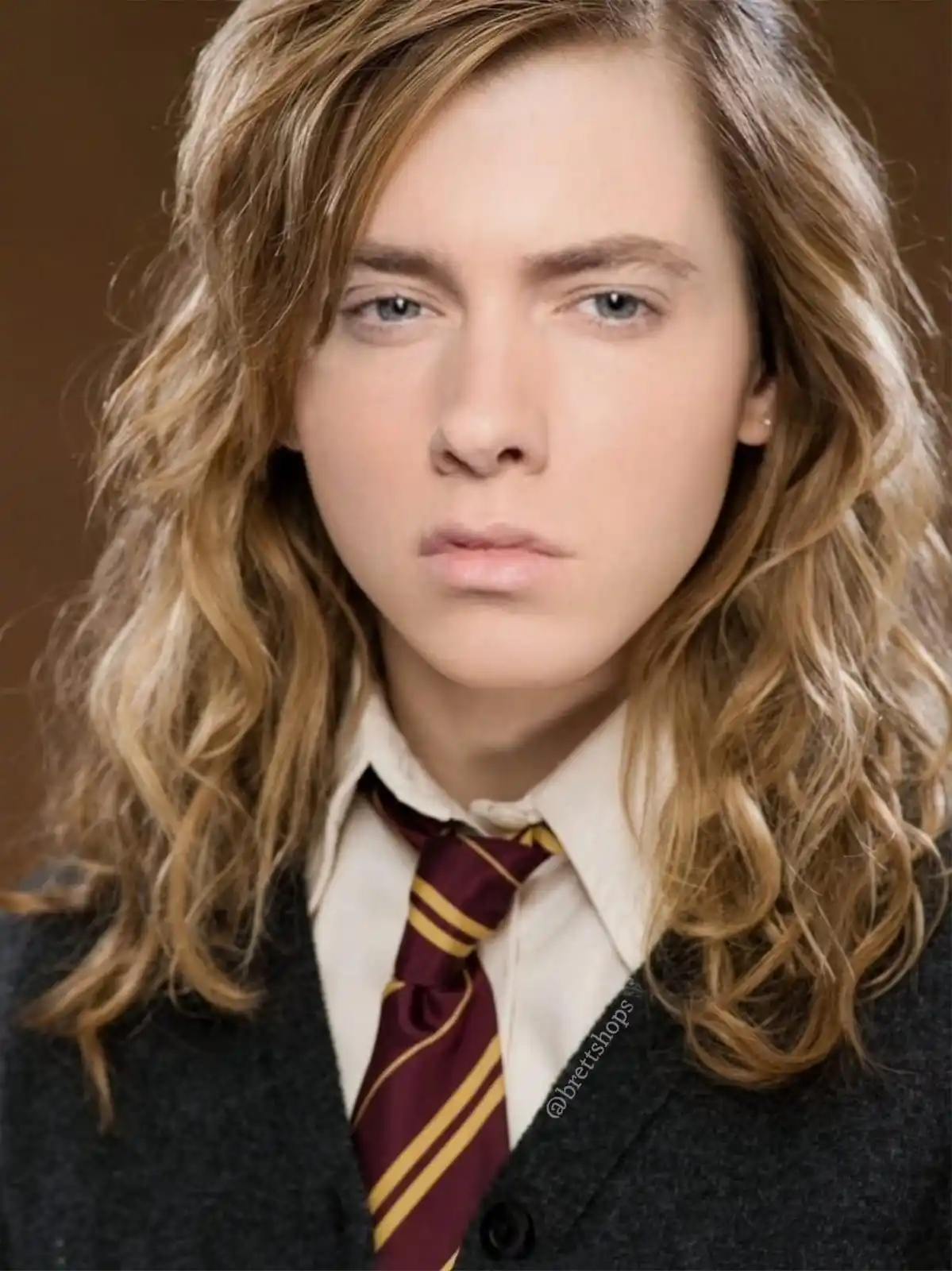 A person with long, wavy, light brown hair wearing a school uniform with a maroon and gold striped tie and a dark cardigan…