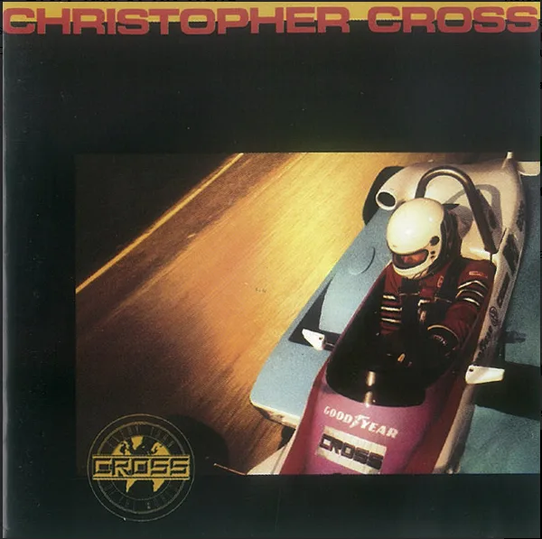 The image is the album cover for Christopher Cross, showing a person in a racing helmet driving a sleek, low-profile race…