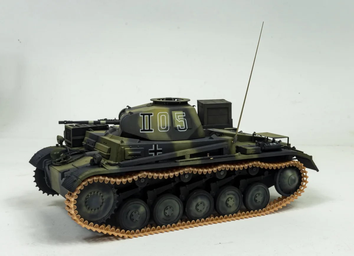A detailed scale model of a German World War II tank, painted in olive drab and black camouflage, with the number 'I05'…