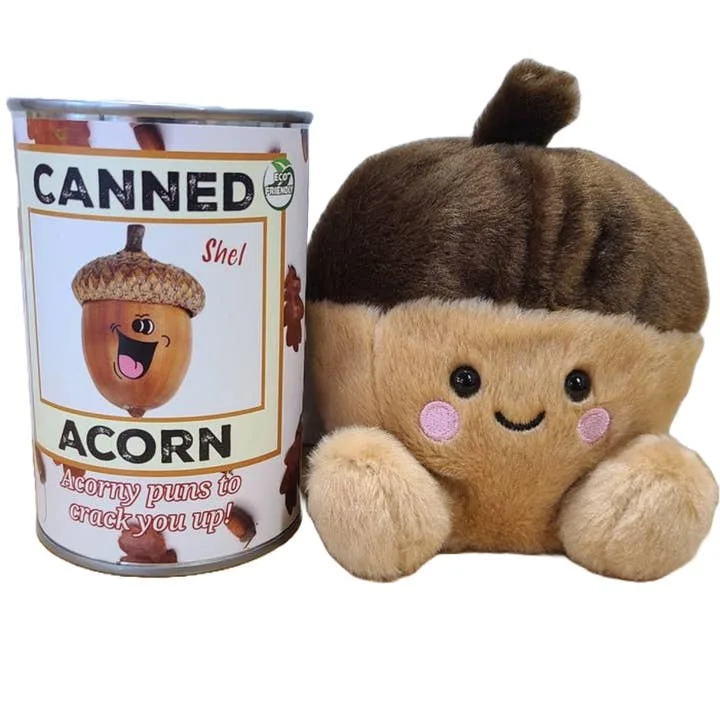A plush toy shaped like a smiling acorn sits next to a can labeled 'CANNED Shel ACORN' with the tagline 'Acorny puns to…