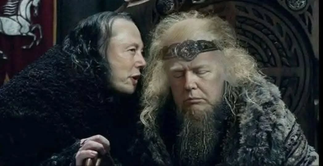 a man in a dark fur cloak leans in to whisper to another man with long blonde hair and a beard, who is seated and appears to…