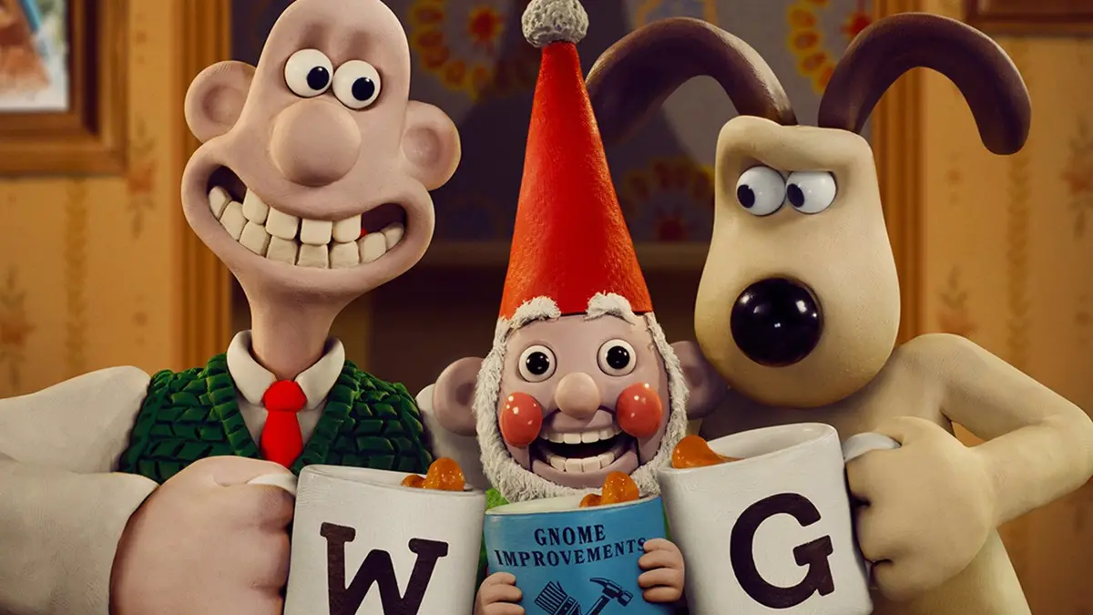 Three claymation characters, Wallace (left, smiling, in green vest and red tie), a gnome (center, in red hat, holding a…