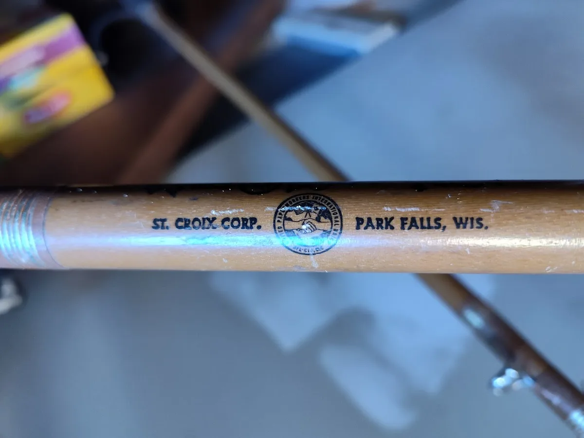 A close-up photo of a wooden fishing rod with a printed logo and text reading 'ST. CROIX CORP. PARK FALLS, WIS.' The rod…