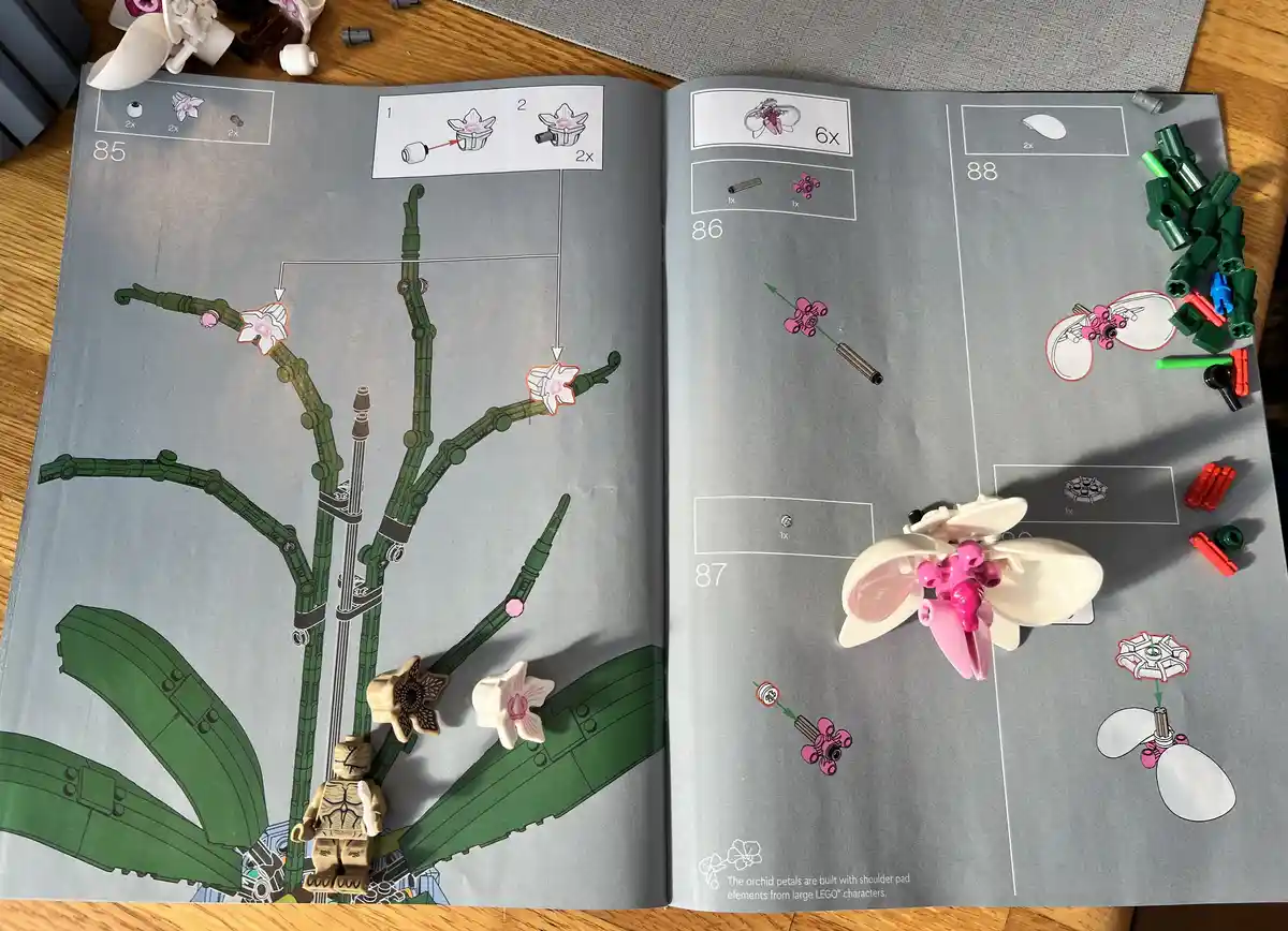 An open LEGO instruction manual shows pages 85-88 for building an orchid plant, with diagrams and part counts. On the right…
