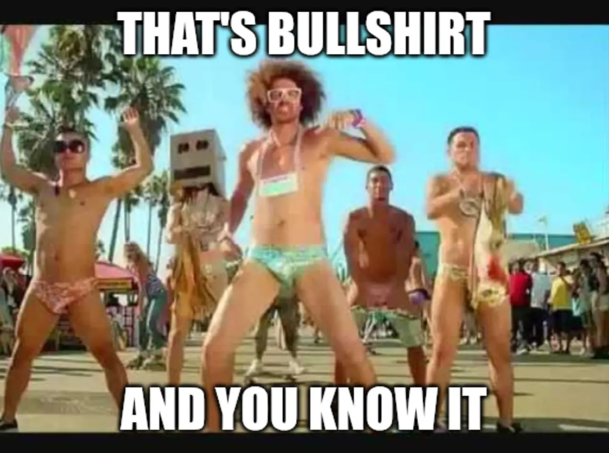 A still from a beach party scene shows several shirtless men in swim trunks dancing energetically under a bright blue sky…