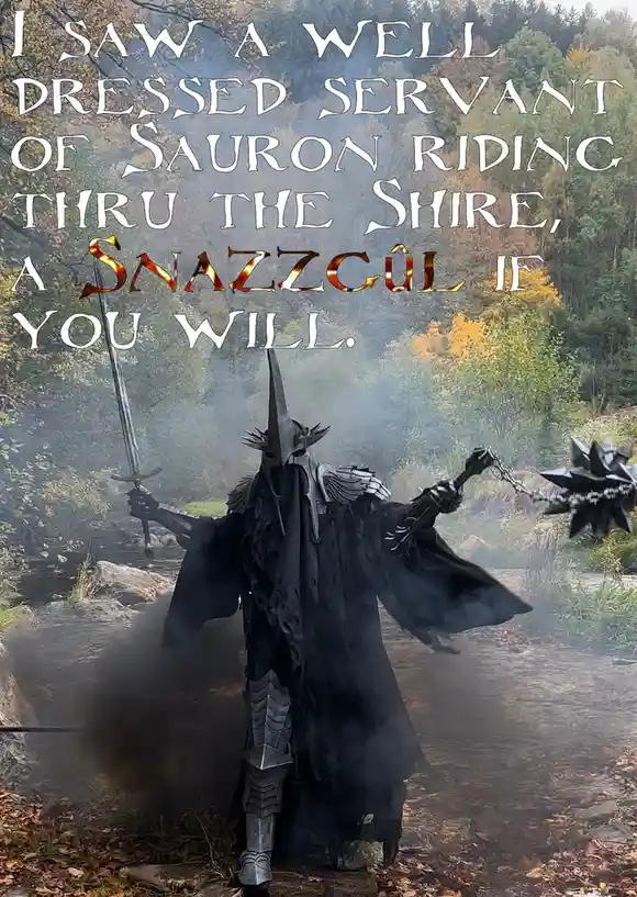 A person in a detailed, dark costume resembling a Nazgûl from Lord of the Rings stands in a misty forest path, holding a…