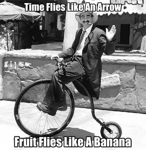 A black-and-white photo of a man in a suit and hat riding a penny-farthing bicycle, waving. Text at the top reads 'Time…