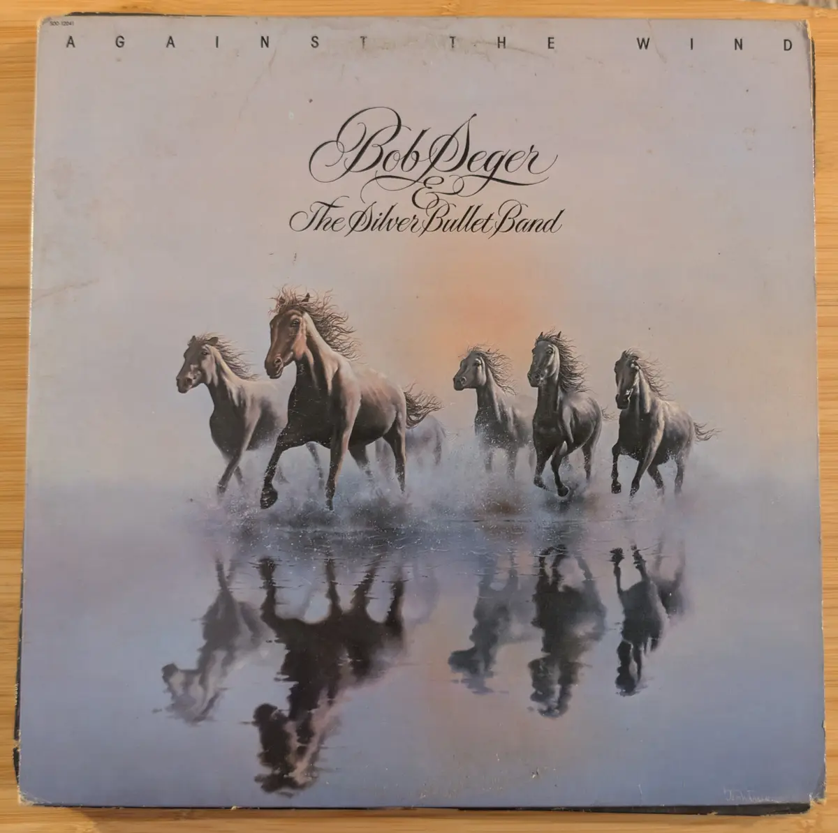 A vintage album cover for Bob Seger and The Silver Bullet Band's 1979 album 'Against the Wind', featuring a painting of five…
