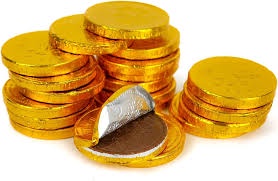 A pile of golden-wrapped chocolate coins, one broken open to reveal a silver foil wrapper inside the chocolate. The text…