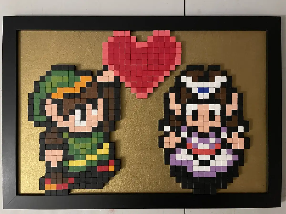 A framed artwork made of colorful wooden blocks depicts two pixelated characters, Link and Zelda from The Legend of Zelda…