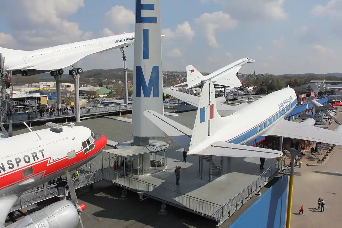 An aerial view of an aviation museum with several large airplanes on display, including an Air France Concorde and a Boeing…