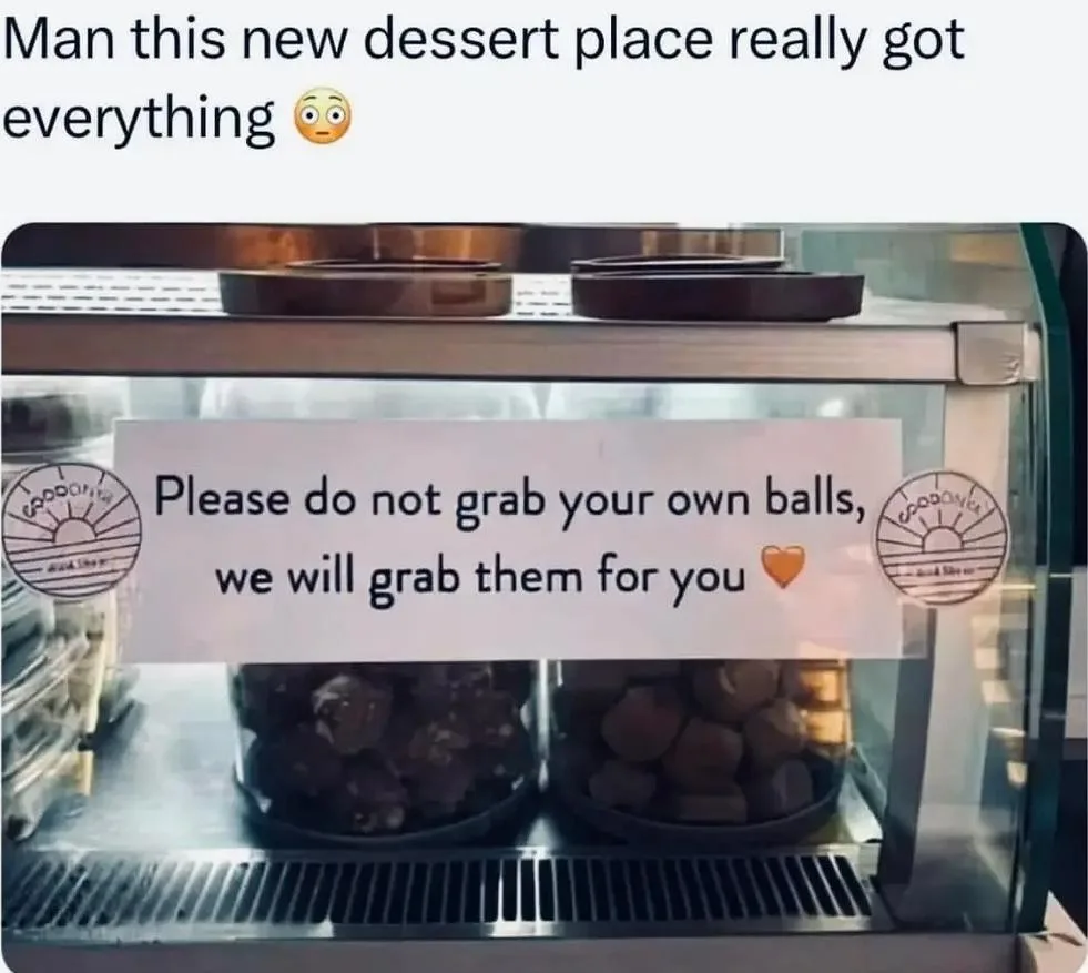 A photo of a dessert display case with two jars of round, dark treats, likely chocolate truffles or similar confections. A…