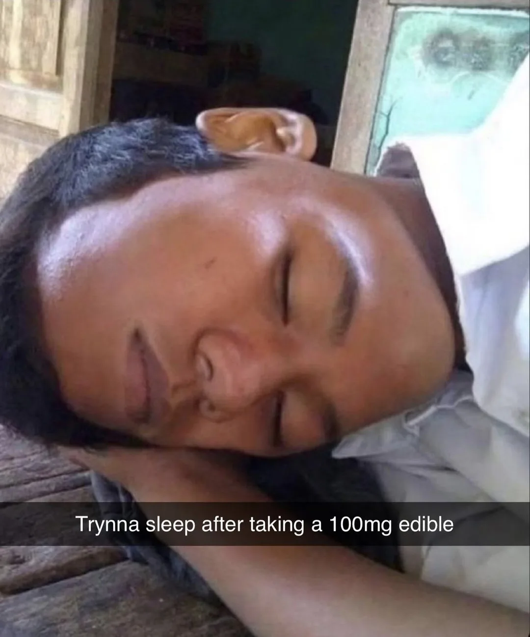 A person is lying down with their eyes closed and head resting on their hand, appearing deeply asleep or exhausted. The…