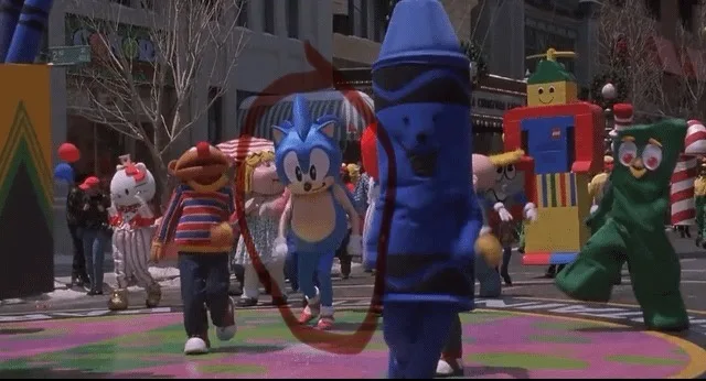 A parade scene with various cartoon mascots, including Sonic the Hedgehog in the center, walking on a colorful street. A…